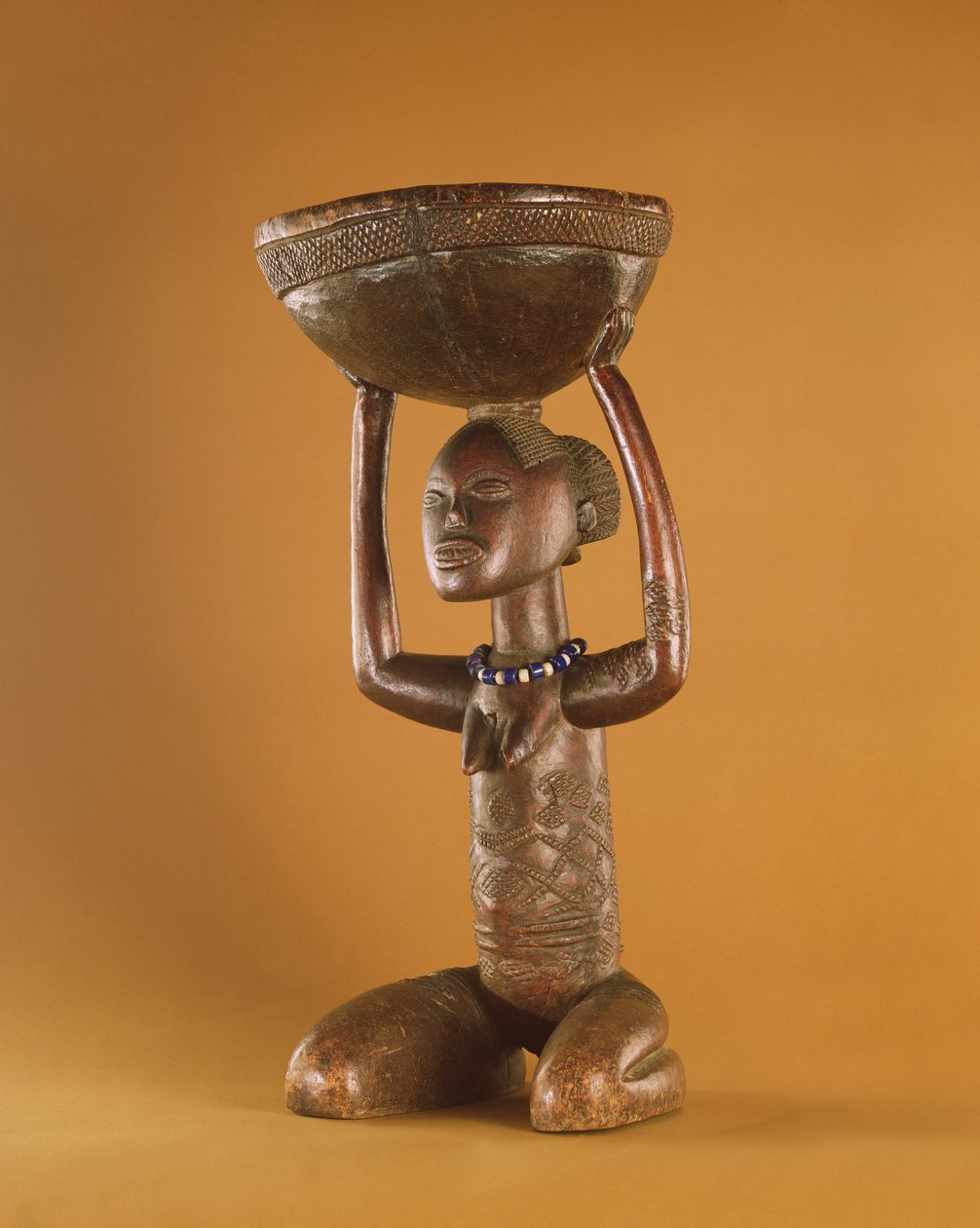 Diz çökmüş dişi karyatidli tabure, Demokratik Kongo Cumhuriyeti (tahta ve cam boncuklar) (ayrıca bkz. 356005) by African