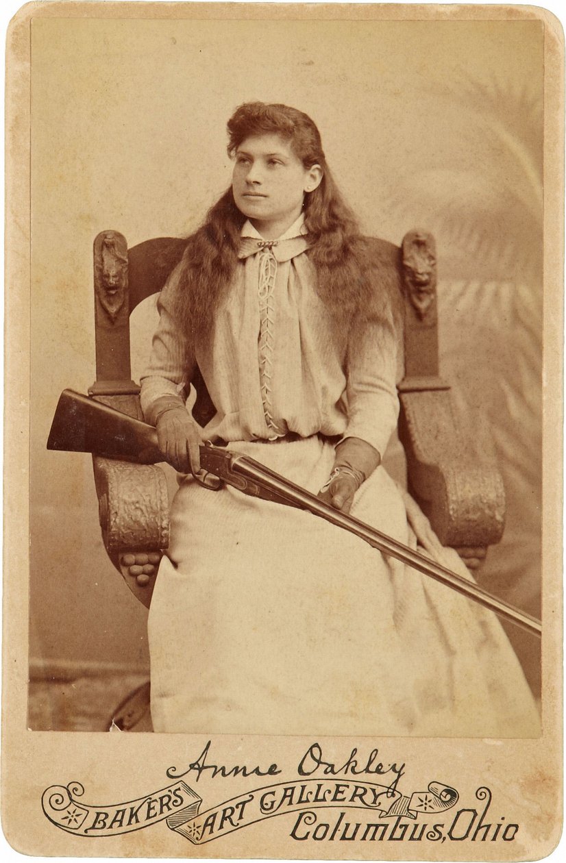 Annie Oakley: Annie Oakley:. Burada Efsanevi Keskin Nişancı, Kucağında Bir Pompalı Tüfekle Rönesans Tarzı Devasa Bir Sandalyede Oldukça Ağırbaşlı Oturuyor. Narin Kadınsı Özellikleri ve Dalgalanan Saçları, Doğadaki Engebeli Ortamını Gizliyor Görüntü ©Buyenl by American Photographer