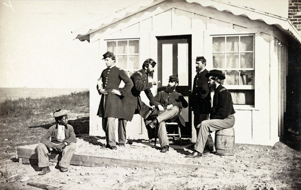 Beş İç Savaş askeri evinin dışındaki toprak verandada toplandı, Afrikalı Amerikalı genç yanlarında oturuyor, 1861-65 by American Photographer