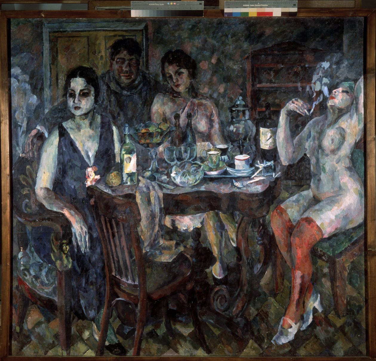Sanatçı Stüdyosunda. Ressam kendini sigara içerken, etrafı çıplak kadınlarla çevrili bir masanın yanında, semaver, şarap şişeleri, bardaklar, bardaklar ve bir kase meyve ile temsil ediyor. Erotik, ağır ve durgun bir atmosfer by Aristarkh Vasilievic Lentulov