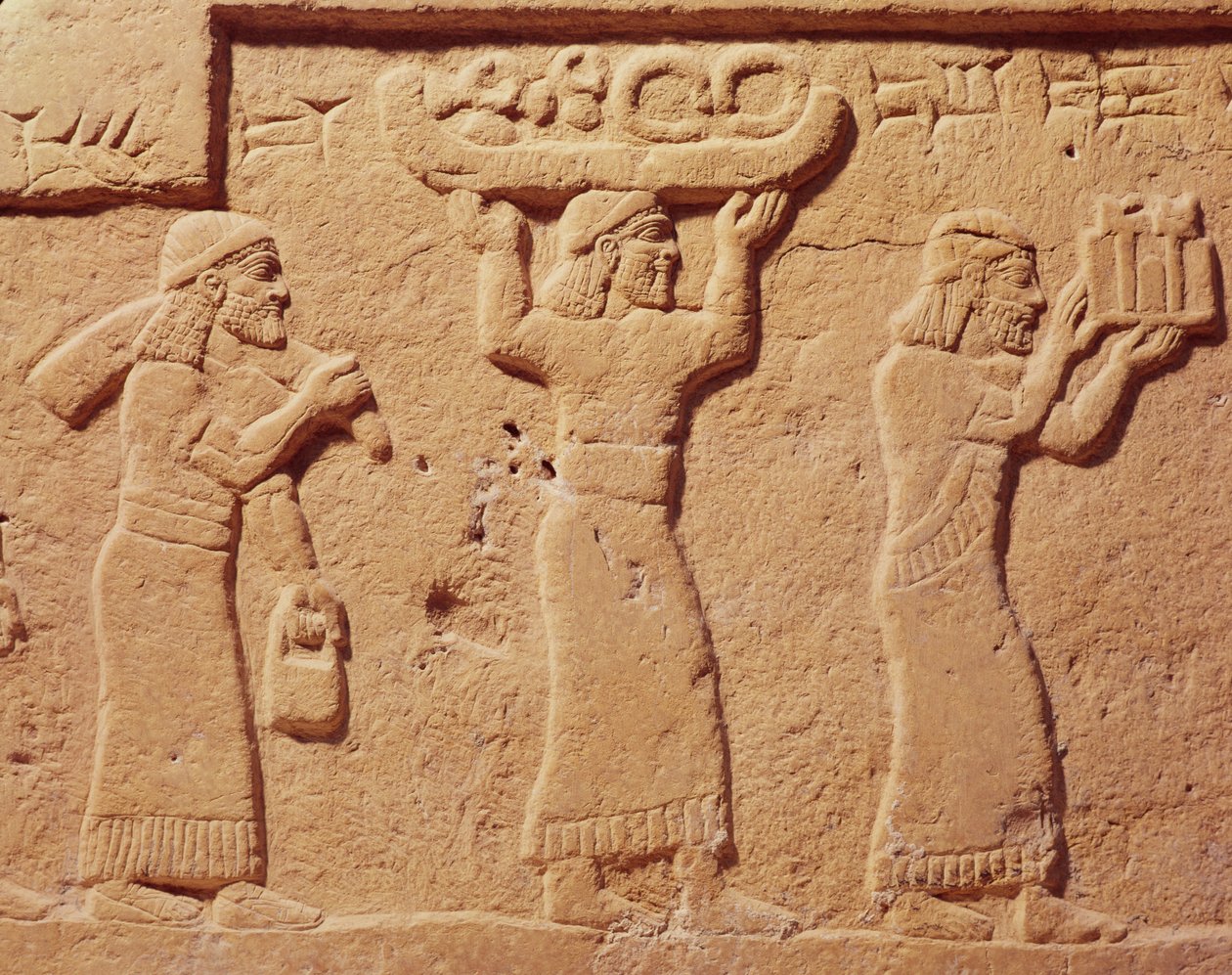Hediyelerle dolu hamalları gösteren kabartma by Assyrian