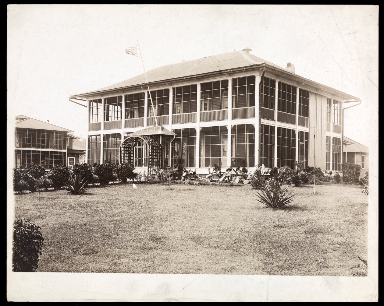 Etrafı verandalarla çevrili, Amerikan bayrağı dalgalanan iki katlı bir ev; Panama