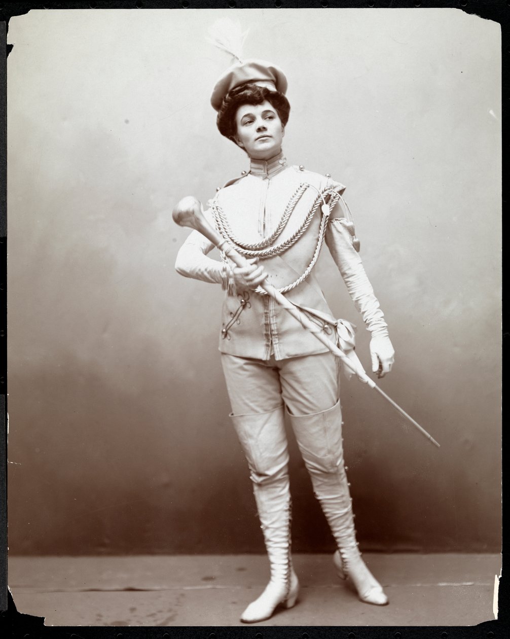 Bir bando üniformasını modelleyen, elinde cop tutan bir kadın, 1898 dolayları (gümüş jelatin baskı) by Byron Company
