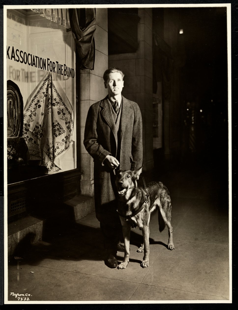ನ್ಯೂಯಾರ್ಕ್ ಅಸೋಸಿಯೇಷನ್ ಫಾರ್ ದಿ ಬ್ಲೈಂಡ್, 111 ಈಸ್ಟ್ 59 ನೇ ಸ್ಟ್ರೀಟ್, ನ್ಯೂಯಾರ್ಕ್, 1938 (ಸಿಲ್ವರ್ ಜೆಲಾಟಿನ್ ಪ್ರಿಂಟ್) ಟರ್ಕ್‌ನ ಮುಂಭಾಗದ ಪಾದಚಾರಿ ಮಾರ್ಗದಲ್ಲಿ ಕುರುಡ ಮನುಷ್ಯ ಮತ್ತು ಅವನ ಮಾರ್ಗದರ್ಶಿ ನಾಯಿ by Byron Company