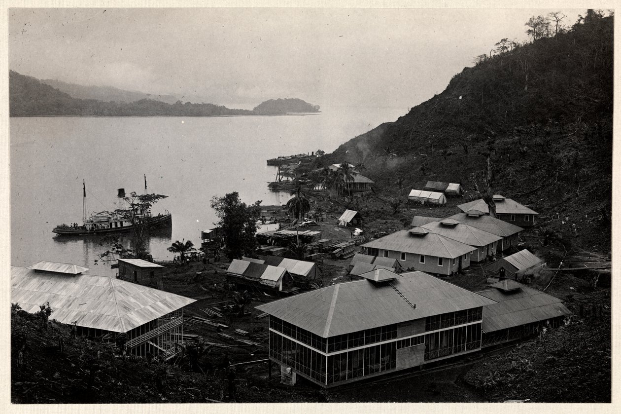 View of a group of buildings near a large body of water during the construction of the Panama Canal, 1912 or 1913 (silver gelatin print) by Byron Company