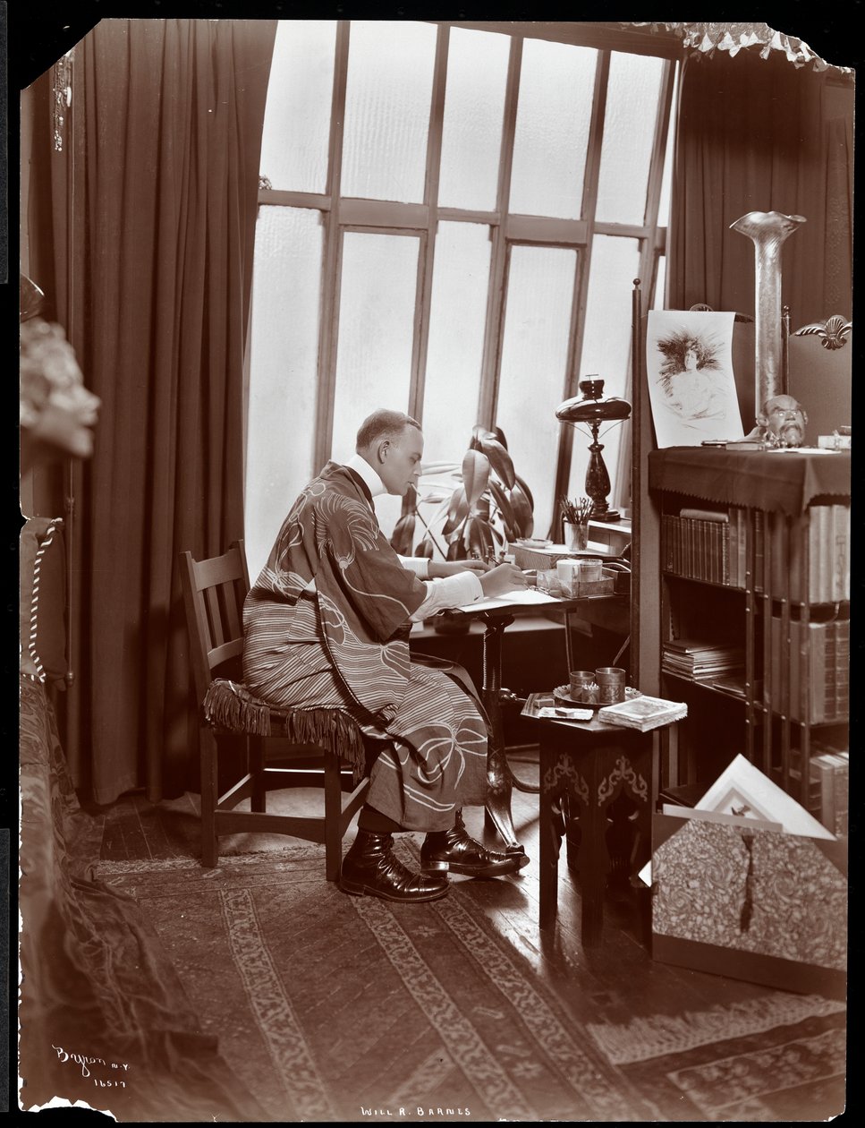 Will R. Barnes bir cüppe içinde, stüdyosunda masasında oturuyor, 1903 (gümüş jelatin baskı) by Byron Company