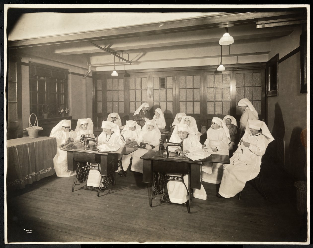 Beyaz önlük giyen kadınlar, dikiş sınıfında, muhtemelen Birinci Dünya Savaşı sırasında veya bununla bağlantılı, New York, 1920 dolayları (gümüş jelatin baskı) by Byron Company