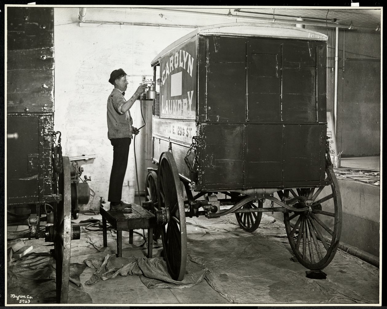 111 East 128th Street, East Harlem, New York, 1929 adresindeki Carolyn Laundry'nin teslimat vagonunu spreyle boyayan bir adam (gümüş jelatin baskı) by Byron Company