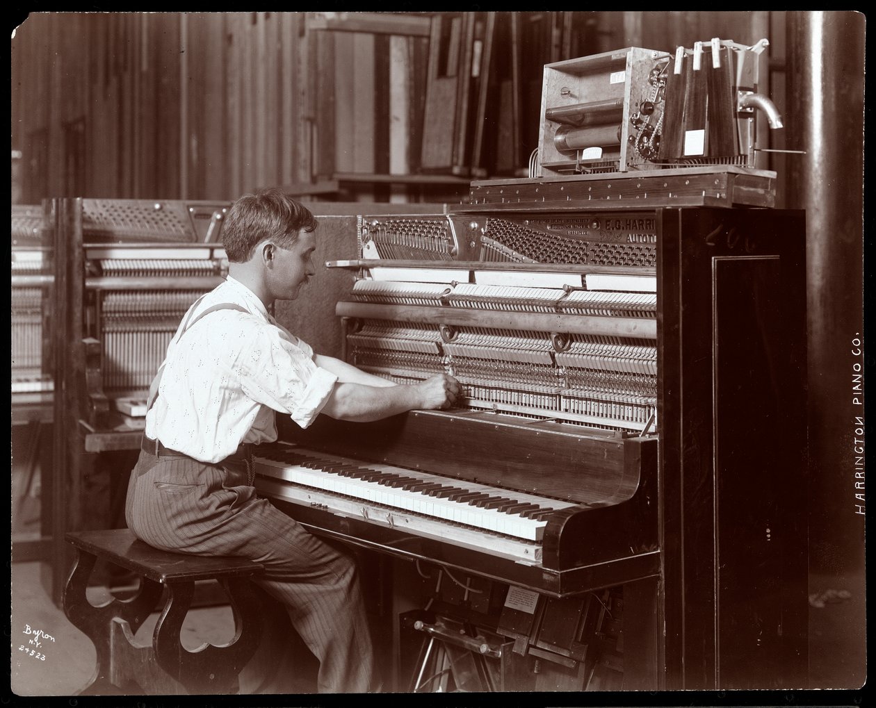 Harrington Piano Co. fabrikasında çalışan bir adam, 1907 (gümüş jelatin baskı) by Byron Company