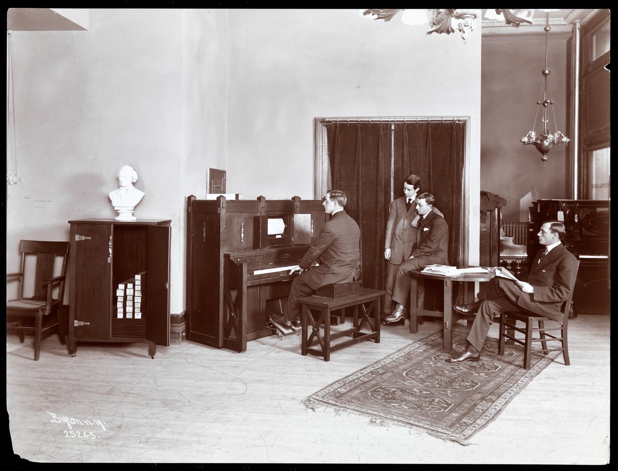 Dört adam, biri H. Bruman Co. çalan piyano çalıyor, 1907 (gümüş jelatin baskı) by Byron Company