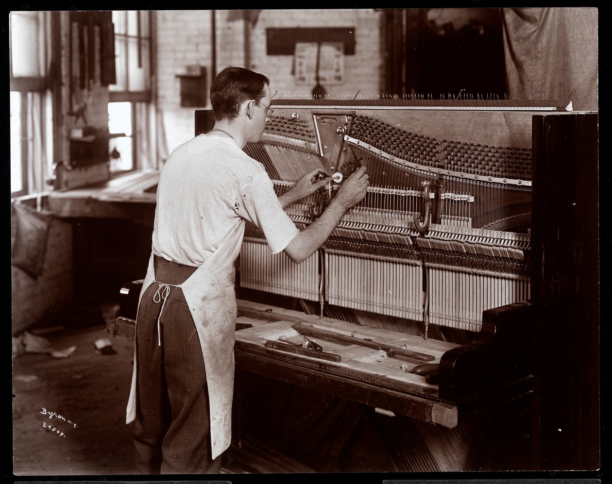Hardman, Peck und Co. piyano fabrikasında çalışan adam, New York, 1907 (gümüş jelatin baskı) by Byron Company