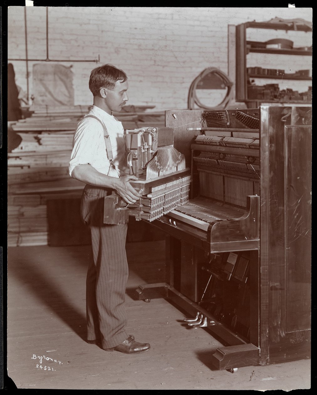 Hardman, Peck und Co. piyano fabrikasında çalışan adam, New York, 1907 (gümüş jelatin baskı) by Byron Company