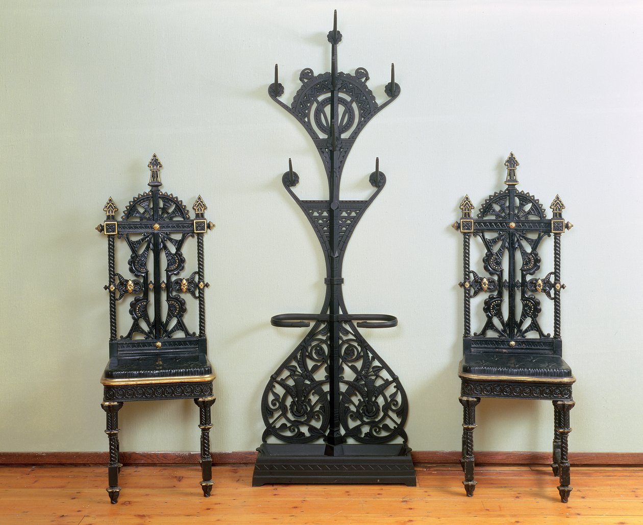İki bahçe veya salon sandalyesi ile çevrili palto, şapka ve şemsiyelik, Coalbrookdale, 1867-69 (dökme demir) by Christopher Dresser