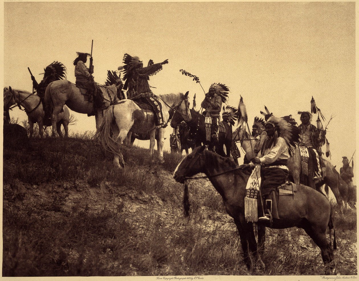 Baskın planlamak. Kızılderililer, etkileyici tipik kıyafetleri içinde son derece pitoresk gruplar halinde bir araya geliyor. Bu, Güney Dakota'daki Pine Ridge Koruma Alanı'ndaki Wounded Knee Vadisi'ne bakan bir tepede bulunan Sioux Ogalala'd by Edward Sheriff Curtis