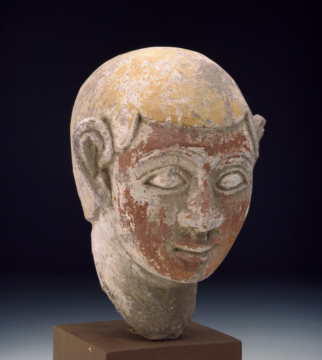 Bir ba heykelinin boyalı kumtaşı başı, c.1-300 (kırmızı ve sarıya boyanmış, oymalı gri kumtaşı) by Egyptian
