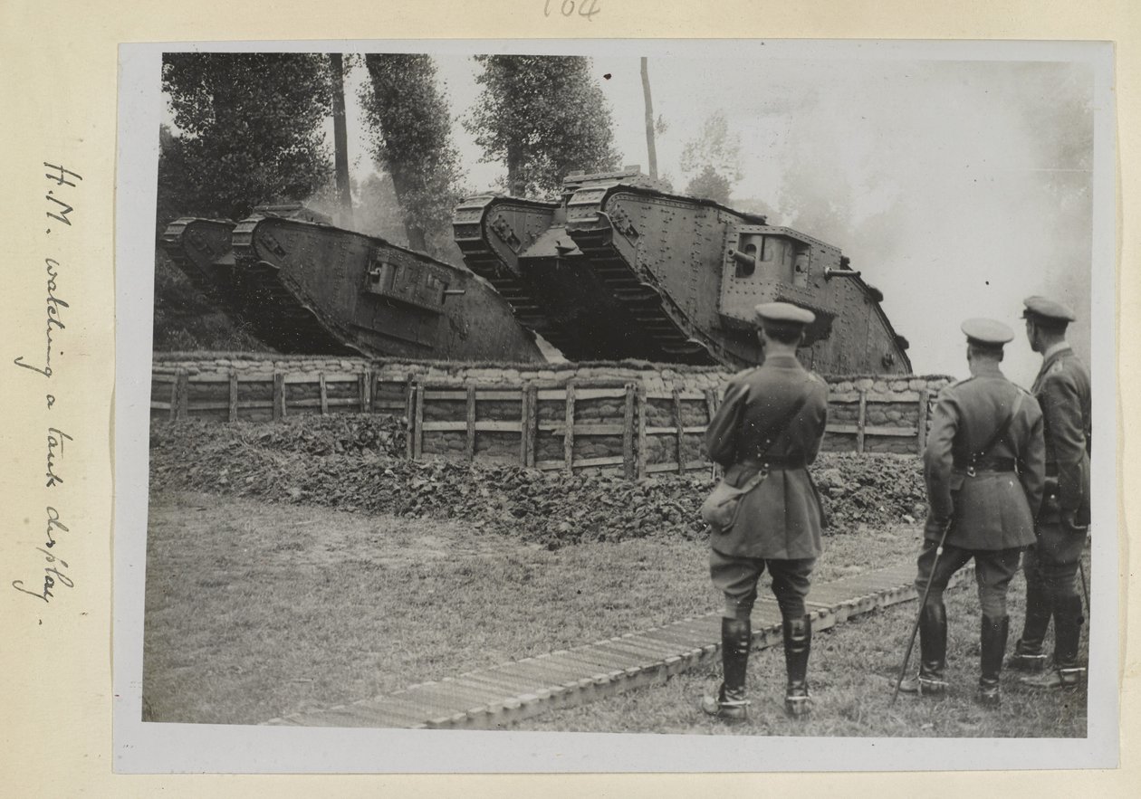 Üç subay, biri muhtemelen King George V, iki tankın bir engel üzerinden sürülmesini izliyor, 1915-18 by English Photographer
