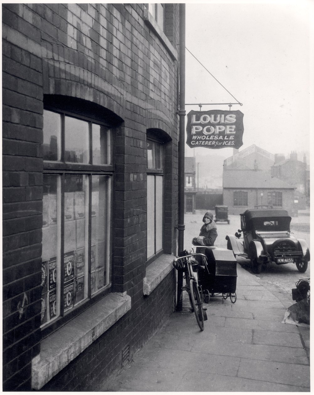 Louis Popes binasının dışında çocuk bakıcısı olan kadın, Lady Lane, Leeds, 1931 by English Photographer