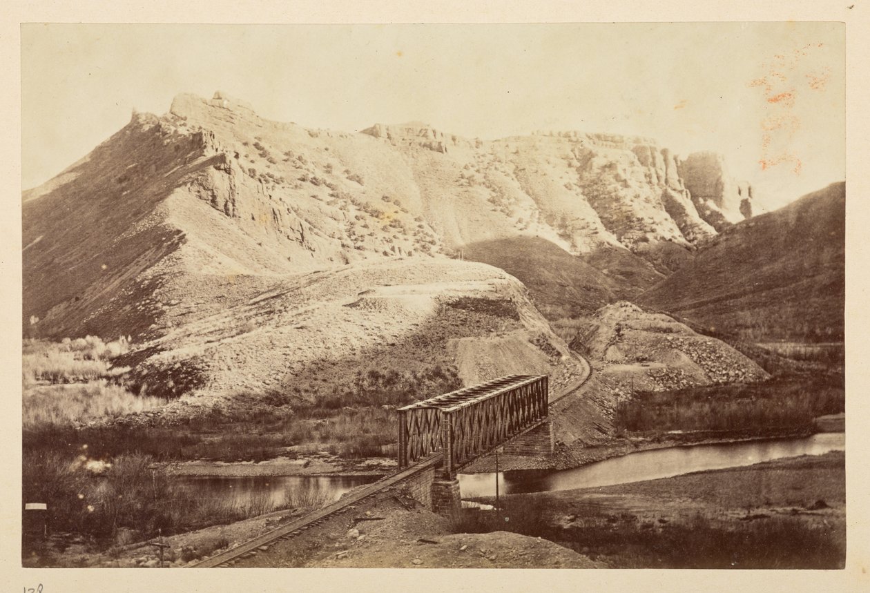Pasifik Demiryolu, ötesinde dağlar ile kirişli bir köprü üzerinde bir nehri geçen demiryolu hattının manzarası by English Photographer