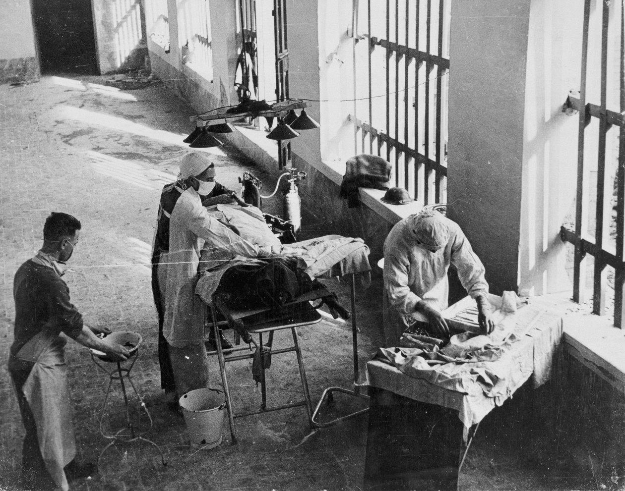 Komuta Derneği tarafından derlenen 650 fotoğraftan oluşan bir koleksiyondan, İkinci Dünya Savaşı sırasında ateş altında bir İtalyan hapishanesinde faaliyet gösteren Saha Cerrahisi Birimi by English School