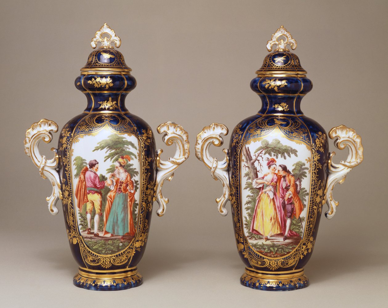 Ağaçlar arasındaki aşıkları betimleyen bir çift Chelsea mavi zemin loblu sivrilen oval vazolar ve kapaklar, 1765 dolayları by English School