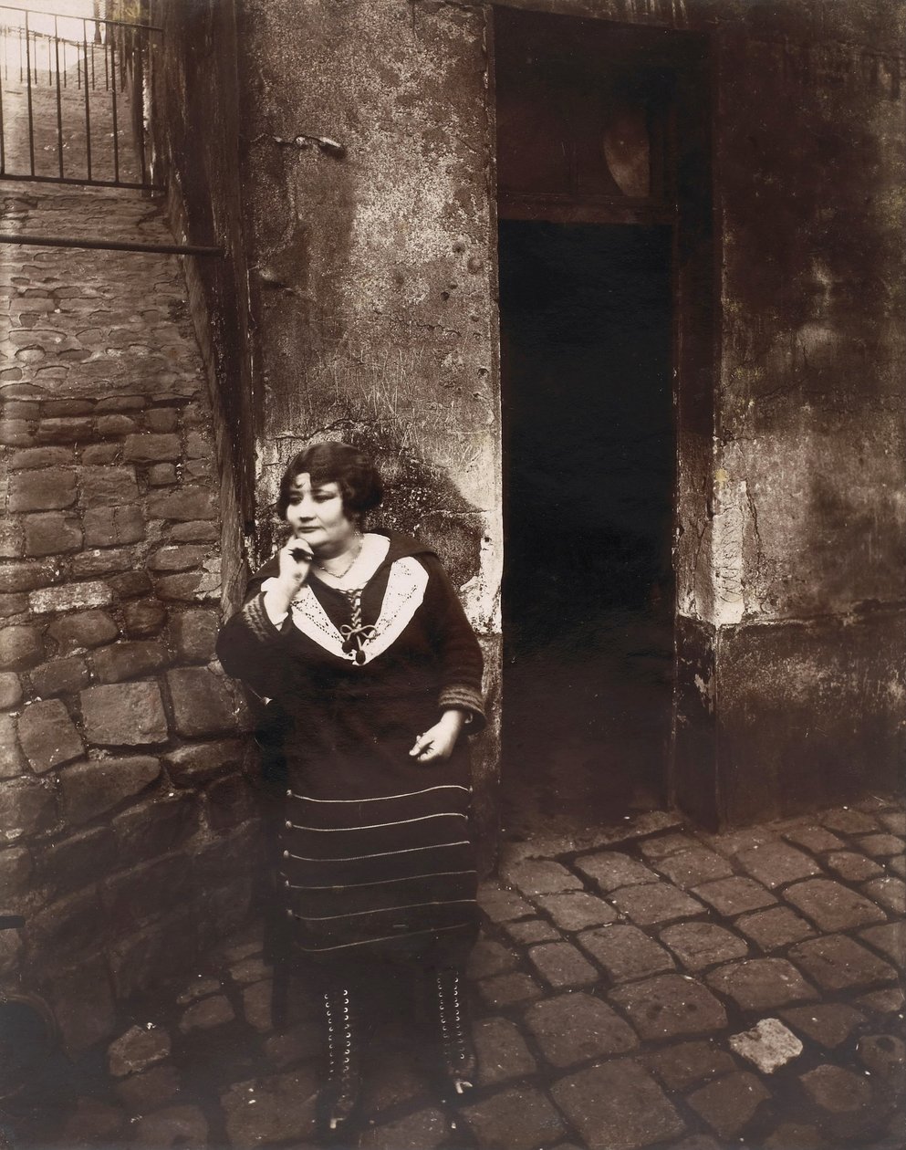 La Vilette. Rue Asselin, kapısının önünde bekleyen fahişe by Eugène Atget
