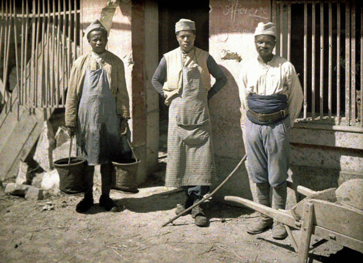 Bir evin önünde Senegalli üç işçi, Soissons, Aisne, Fransa, 1917 (otokrom) by Fernand Cuville