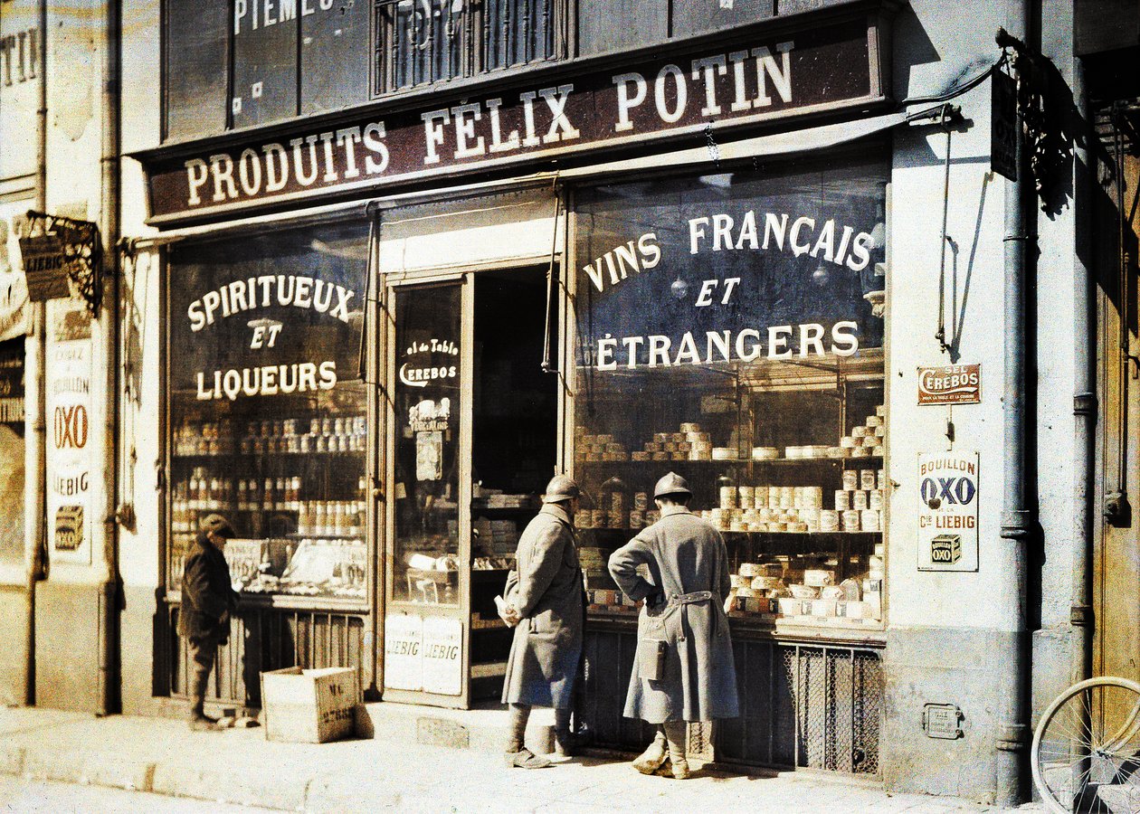 İki Fransız askeri ve bir çocuk likör dükkanının önünde Felix Potin pazarda, Reims, Marne, Fransa, 1917 (otokrom) by Fernand Cuville