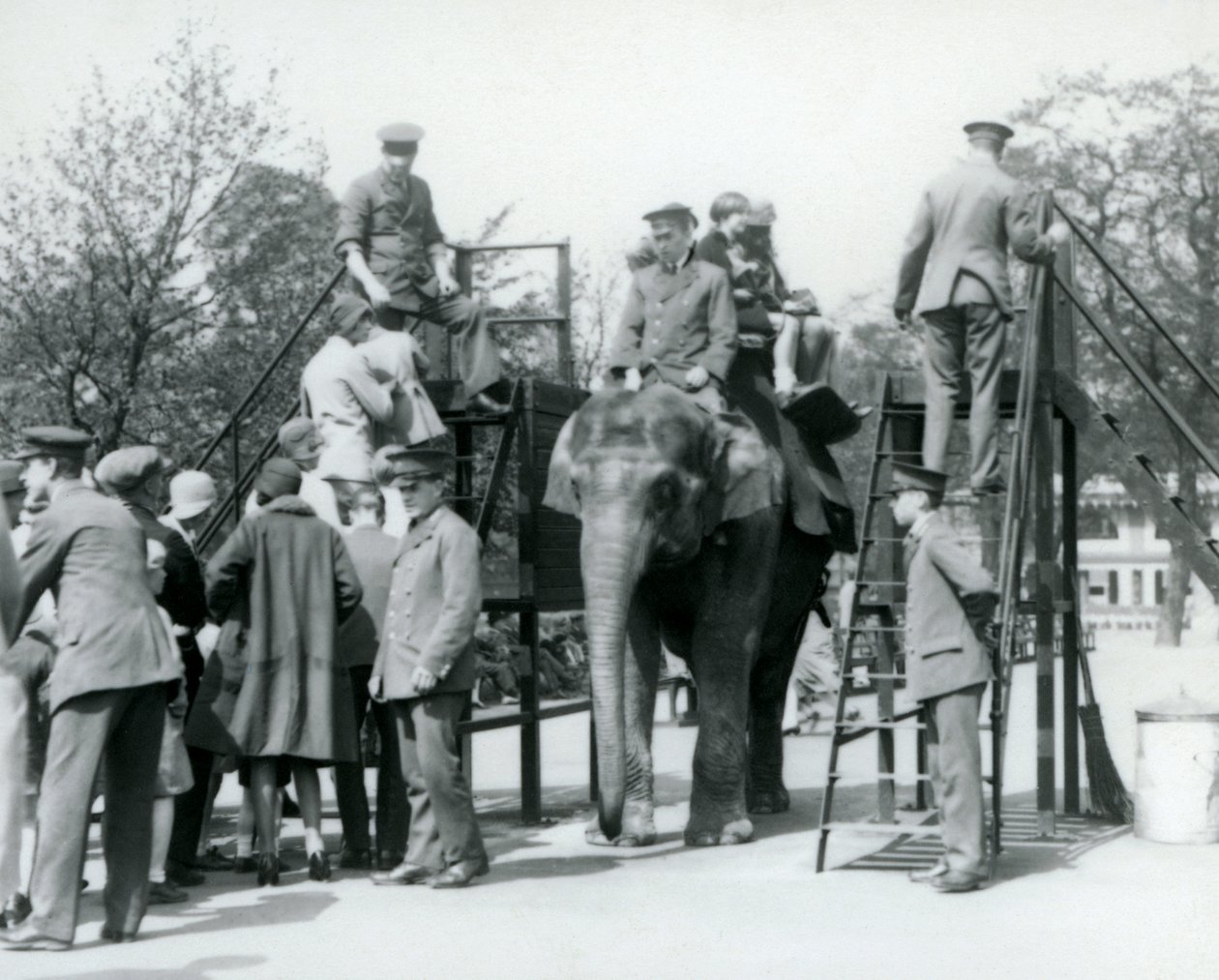 Ziyaretçiler Fil Gezintisi için sıraya girerken diğerleri gemiye biniyor, beş bekçinin yardımıyla, Londra Hayvanat Bahçesi, 1927 by Frederick William Bond