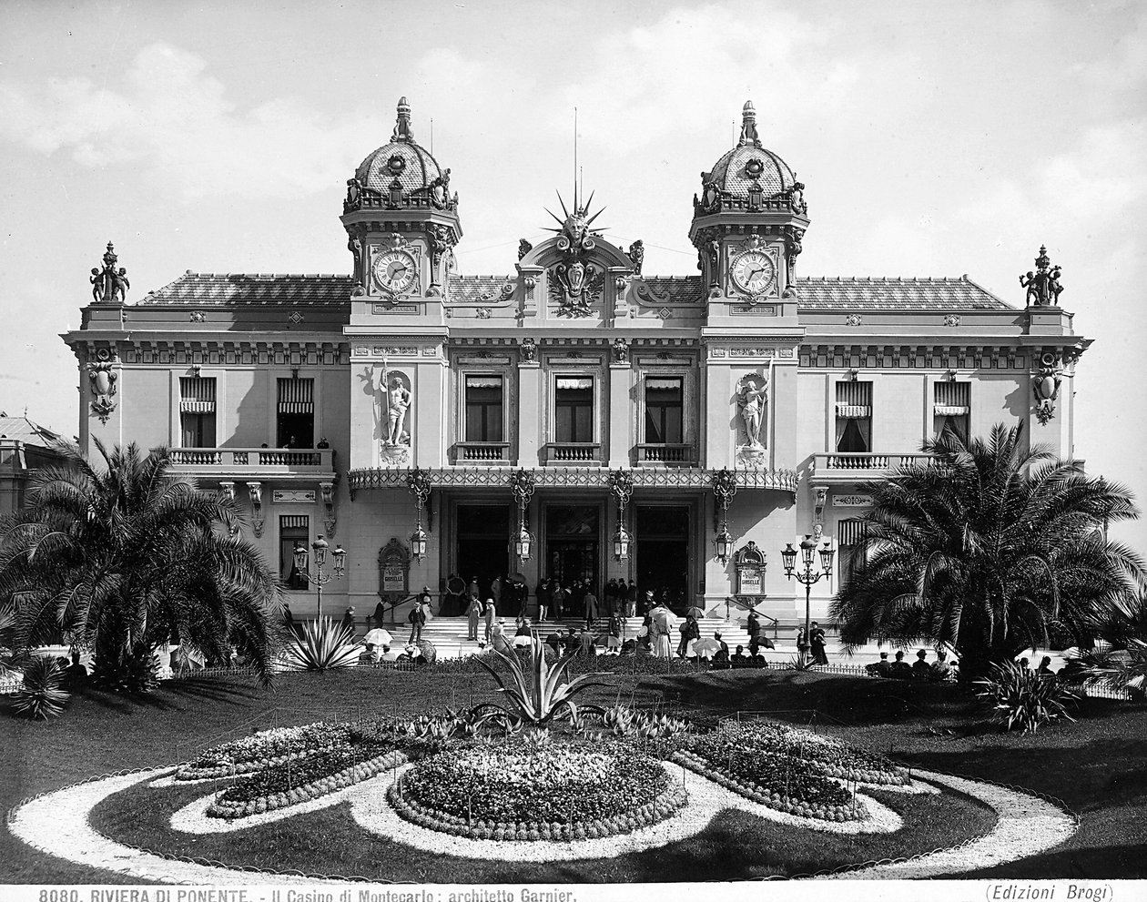Montecarlo kumarhanesinin cephesi. Bir insan kalabalığı girişteki merdiveni canlandırıyor by Giacomo Brogi