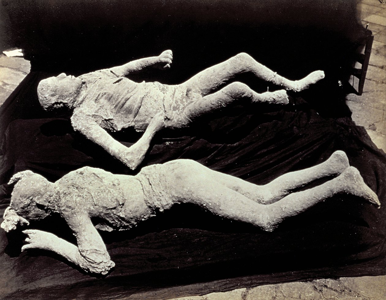 Pompeii kazılarından iki kalıp insan figürü. Sergiler, fotoğraflarını çekmek için siyah kumaş üzerine yerleştirildi. by Giorgio Sommer