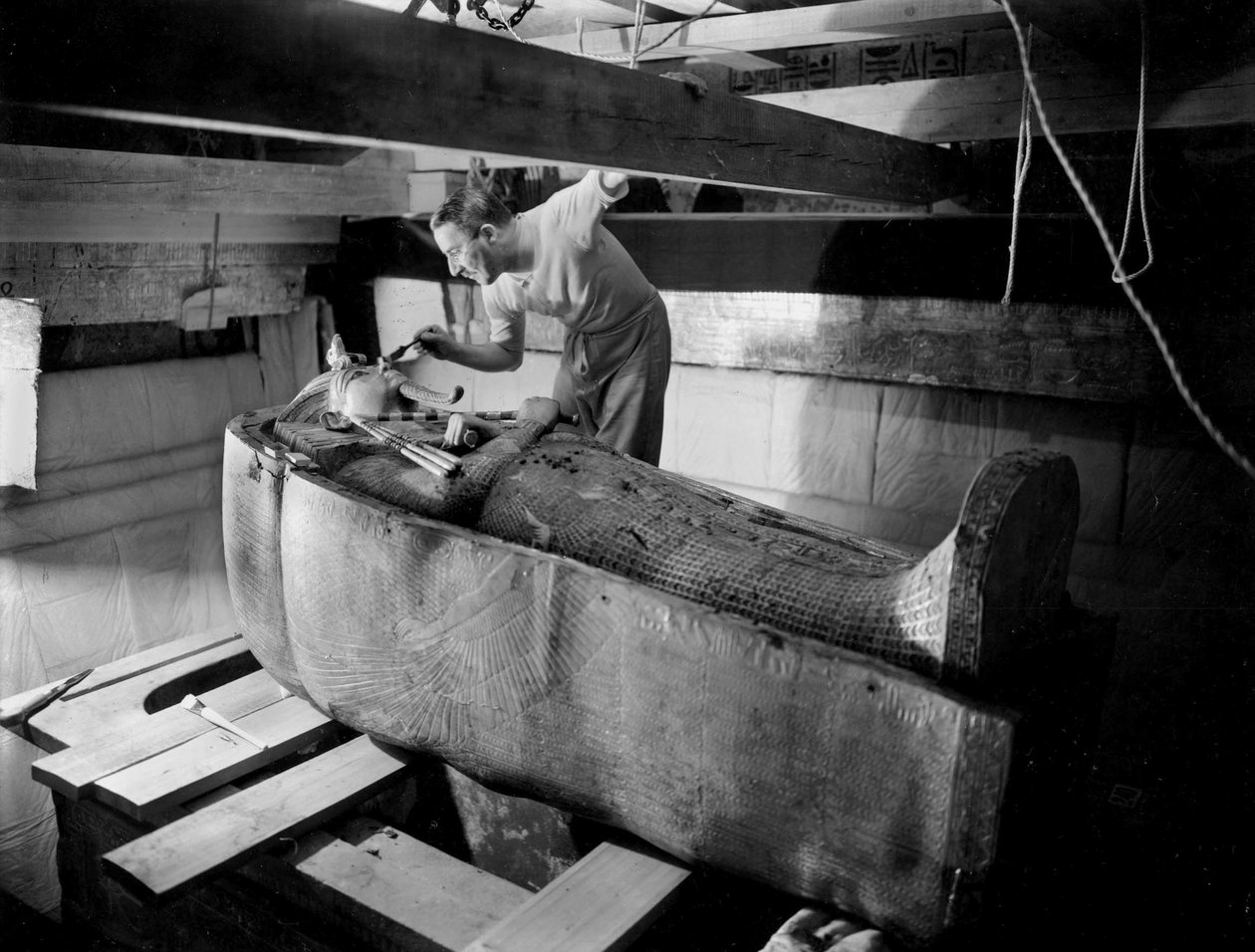 Krallar Vadisi'nde (Mısır) firavun Tutankhamun'un mezarının keşfi: mezar odasında, Howard Carter ikinci tabutun kapağı üzerinde çalışırken, Ekim 1925, fotoğraf, Harry Burton (s1568) by Harry Burton