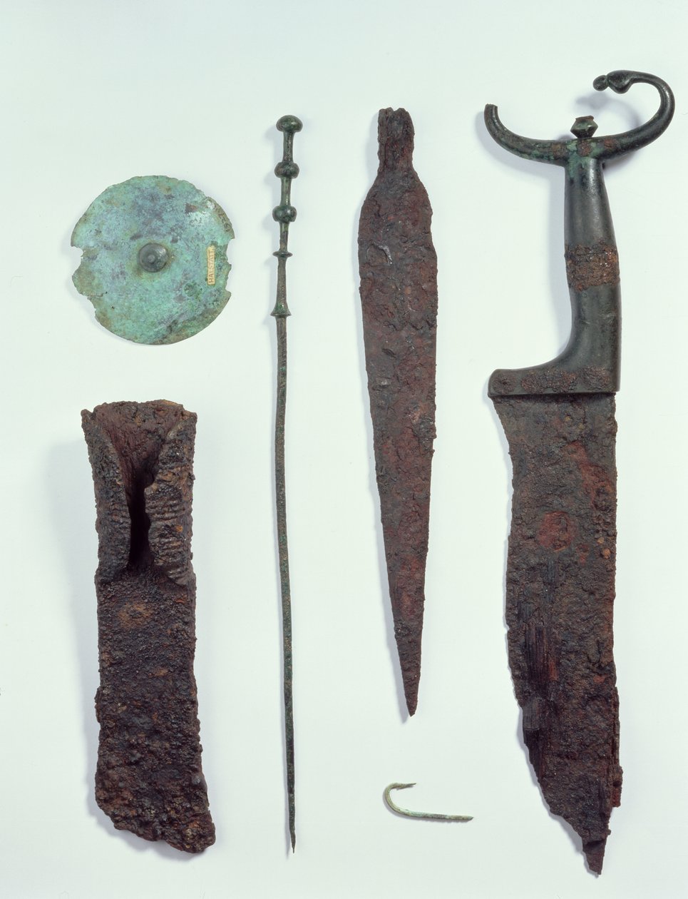 Yukarıdan Aşağıya: Demir Çağı, Hallstatt'taki erkek mezarlarında bulunan bıçak, Mızrak ucu, olta, elbise iğnesi, kemer diski ve balta. by Iron Age