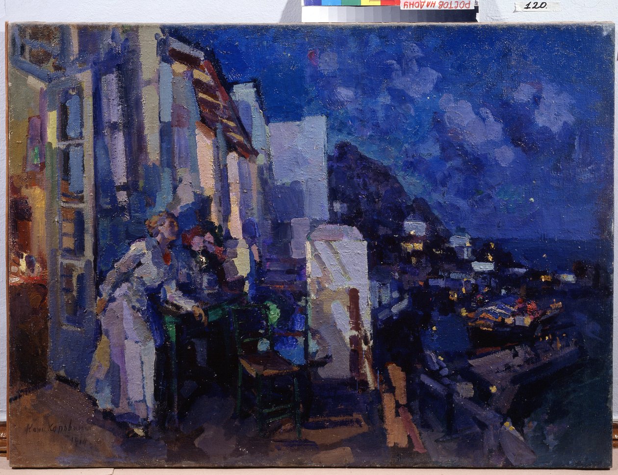 Verandada akşam. Bir kadın, terasının önünde geceye uzanan şehrin panoramasından yararlanıyor. Konstantin Alekseyeviç Korovin