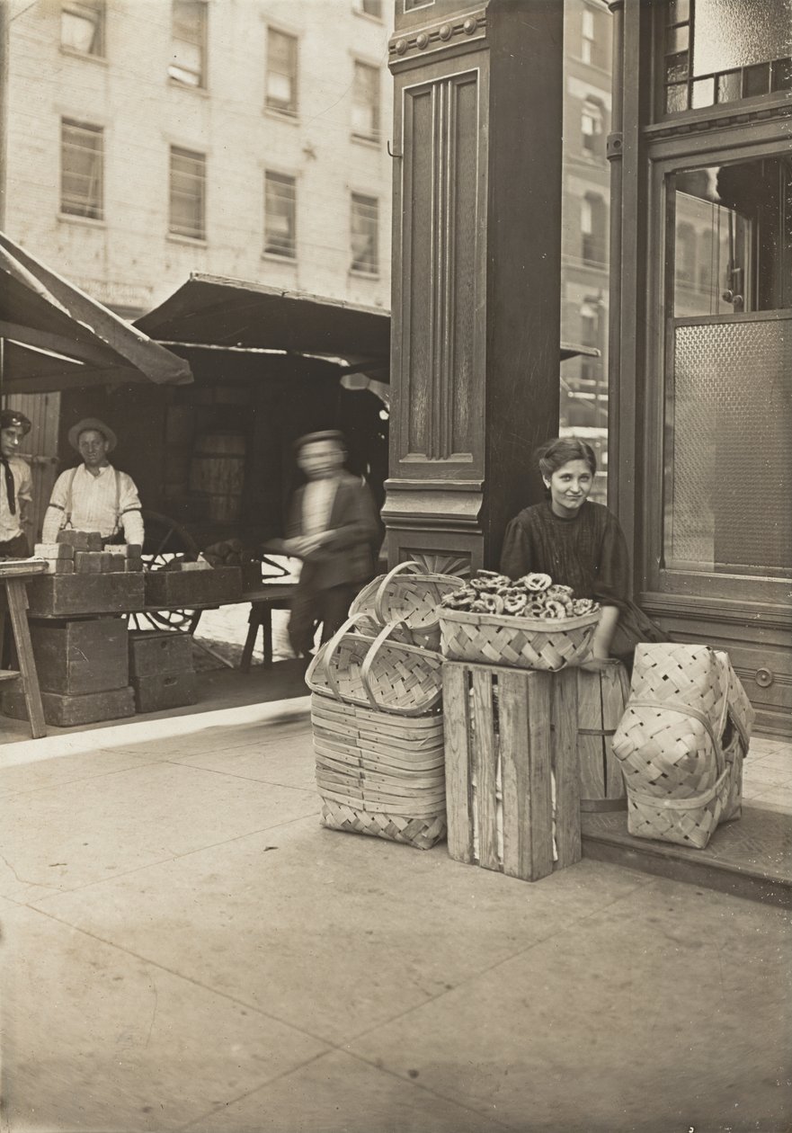 Lena Lochiavo, 11 yaşında, sepet ve simit satıcısı, Sixth Street pazarında salon girişinin önünde, Cincinnati, Ohio, Ağustos 1908 (jelatin gümüş baskı) by Lewis Wickes Hine