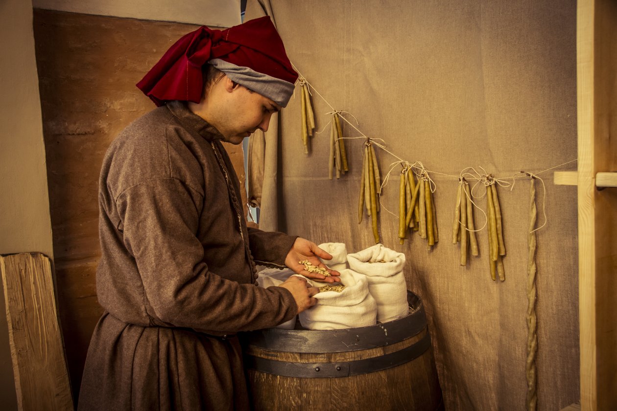 Tarihsel canlandırma: Diotaiuti, Imola, İtalya, 14. yüzyıl ortası eczacısında buğday, çavdar ve arpa mumları ve çuvalları (fotoğraf) by Unbekannt Unbekannt