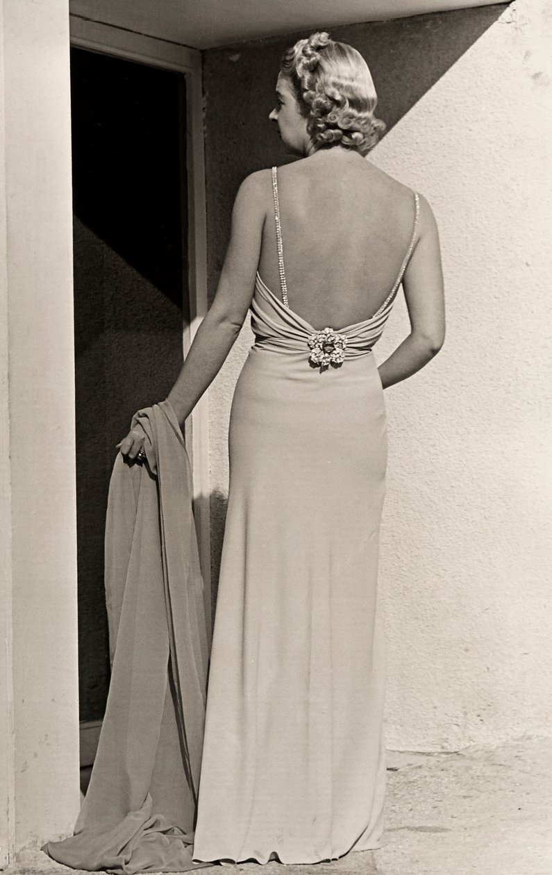 Arkadan görülen model, moda evi "Fumach" dan gece elbisesi giyiyor. Ürün arka kısmı çıplak bırakıyor ve mücevherli bir iğne ile süsleniyor. (s/b fotoğraf) by Luis Bogino