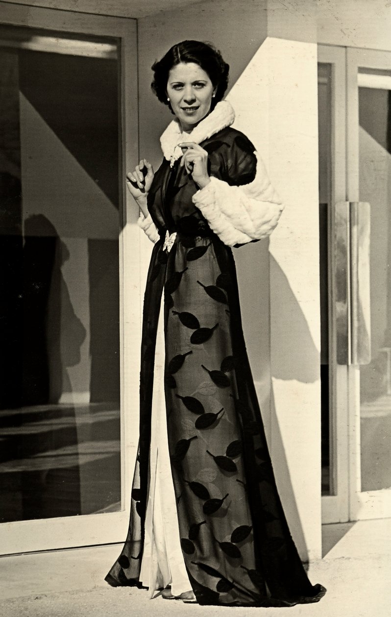Model, İtalyan moda evi "Bernasconi" tarafından yaratılan gece elbisesini giyiyor. Sunulan makale, kürklü yaka ve manşetleri olan bir şifon paltodan oluşmaktadır (s/b fotoğraf) by Luis Bogino