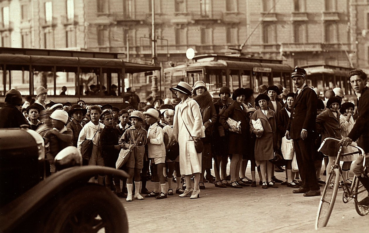 Bir saha gezisi sırasında bir grup öğrenci. Fotoğraf, şehir caddesindeki çocukları, öğretmenlerini ve diğer yayaları gösteriyor (s/b fotoğraf) by Mario Castagneri