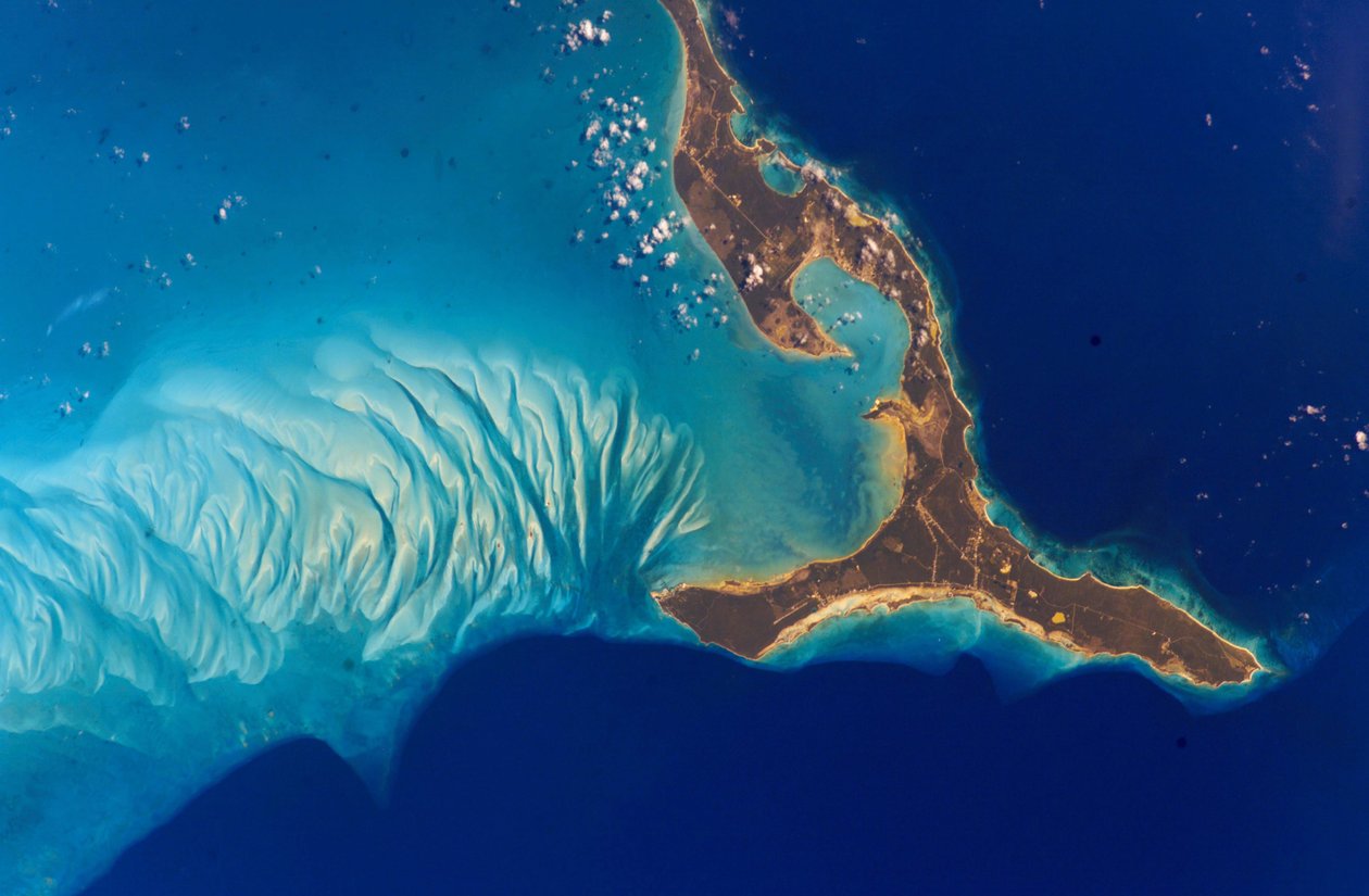 Eleuthera Adası, Bahamalar, 2002. Adanın batısındaki sualtı oluşumları, mercan resiflerinden aşınmış ve okyanus akıntıları tarafından kum tepelerinde biriken kalsiyum karbonat kumundan yapılmıştır. Kredi NASA. Bilim E by National Aeronautics and Space Administration National Aeronautics and Space Administration