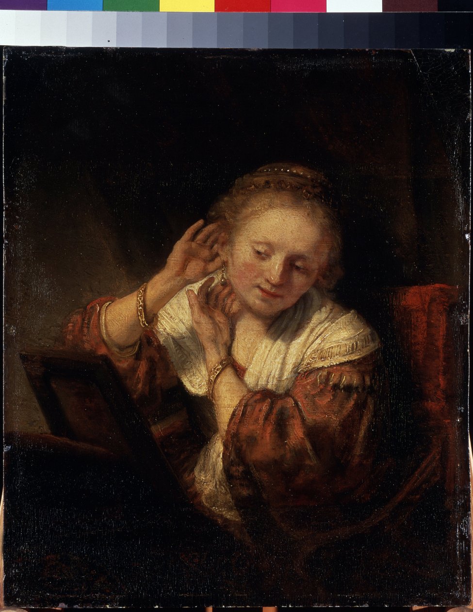 Küpeleri deneyen genç bir kadın. Küpeleri deneyen genç bir kadın. Rembrandt (1606-1669) olarak bilinen Harmenszoon van Rijn tarafından yapılan tablo by Rembrandt Harmensz. van Rijn