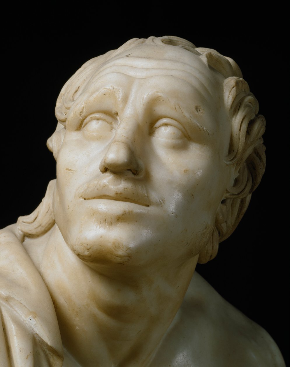Roma sanatı: “” Bıçaklarını bileyen bir kalemtıraş”” Yüzünün detayı. Bir Yunan orijinalinden sonra MÖ 1. yüzyıldan kalma Roma mermeri heykeli. karartmak 105 cm Floransa, Galleria degli Uffizi, Tribuna by Roman