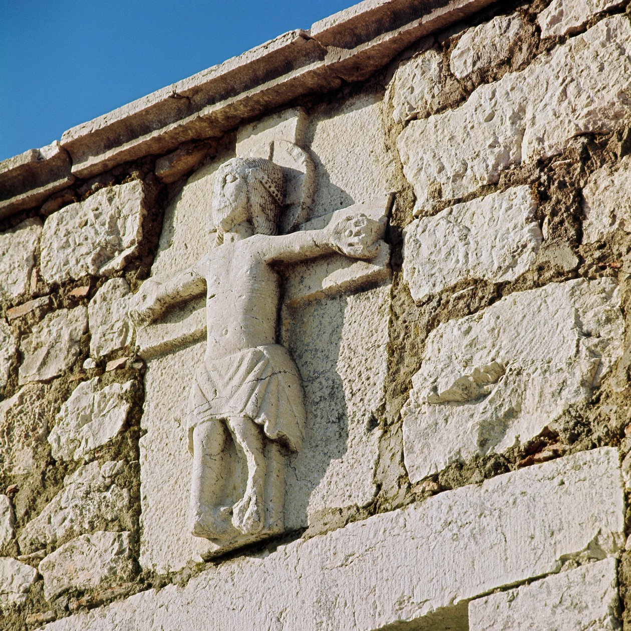 İsa, 13. yüzyılın Taş heykelini çarmıha gerer. San Bartolomeo Romanesk Kilisesi