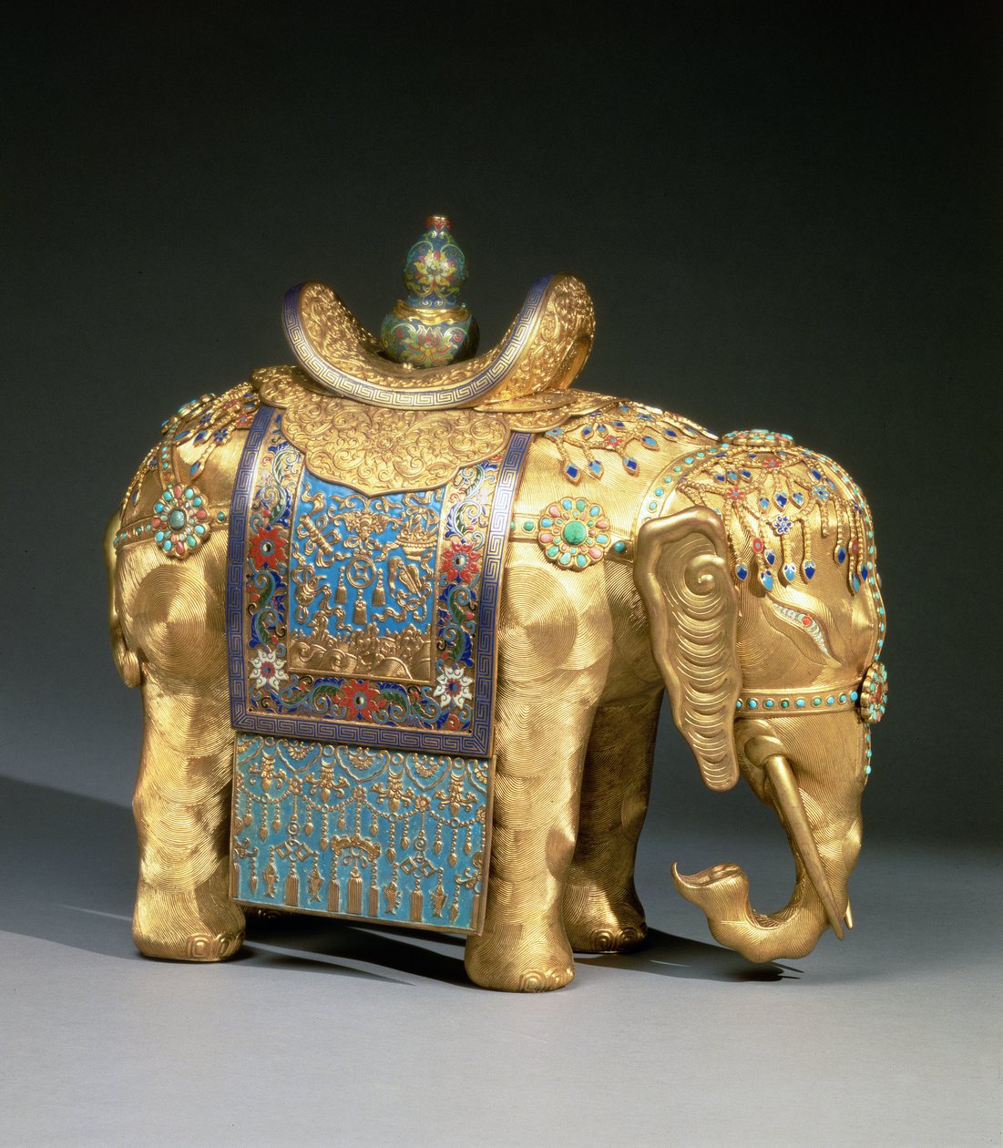 Emaye süslemeli ve mercan ve turkuaz kaboşonlu bir fil figürü, Budist amblemleriyle süslenmiş eyer bezi, Chien Lung Dönemi, c.1780 (yaldızlı bronz, emaye, mercan ve turkuaz) by School Chinese