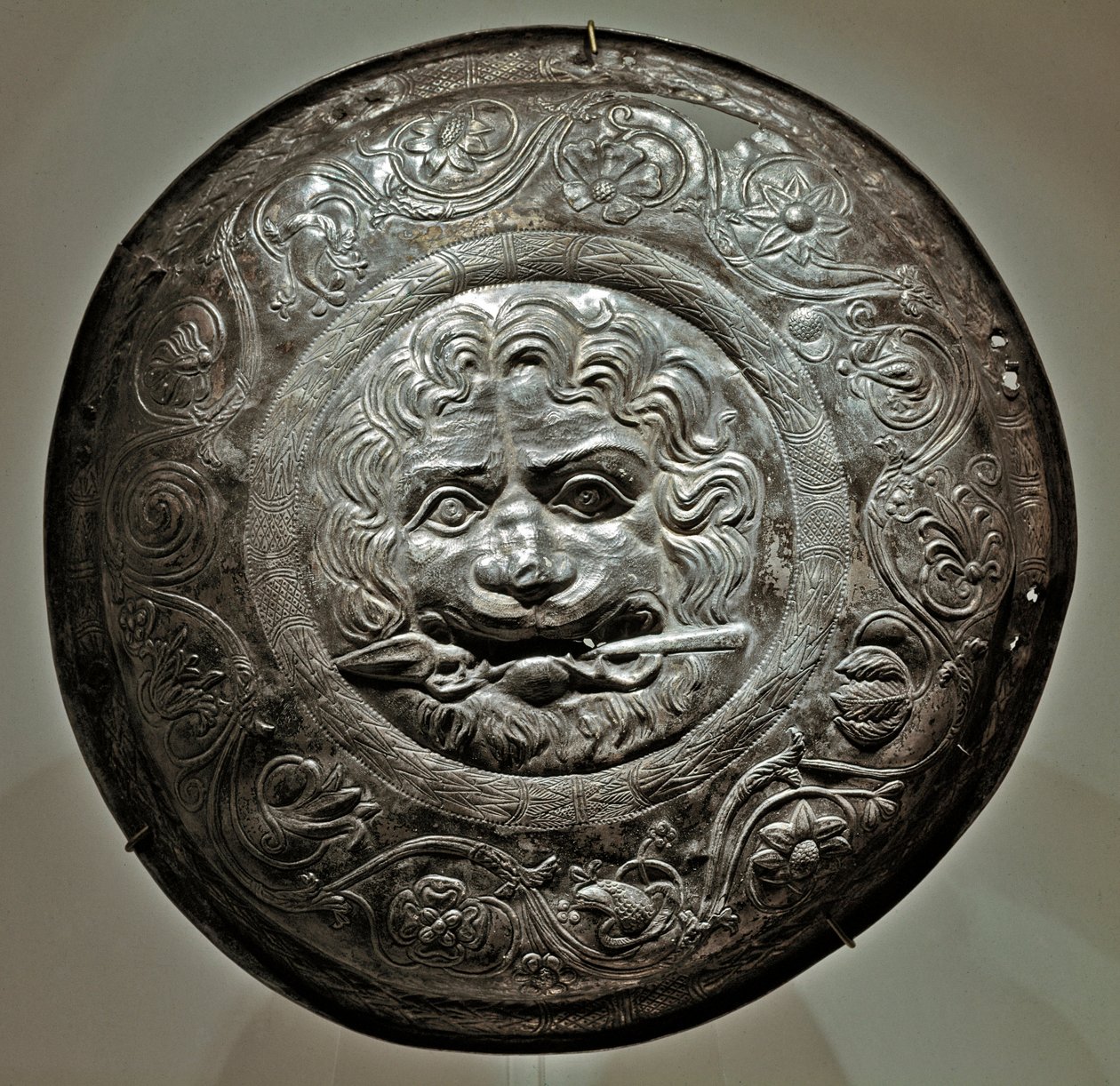 Art Scythian (İskit veya İskit uygarlığı): Rostov bölgesinin ağzında mızrakla aslan başını temsil eden gümüş takı öğesi. Sarmat sanatı, MÖ 2. - 3. yüzyıl. Petersburg Hermitage Müzesi. by Scythian Scythian