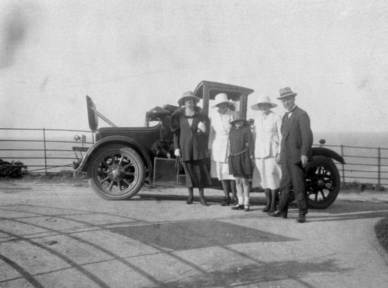 Deniz kenarında arabalarının önünde bir grup insan, c1920