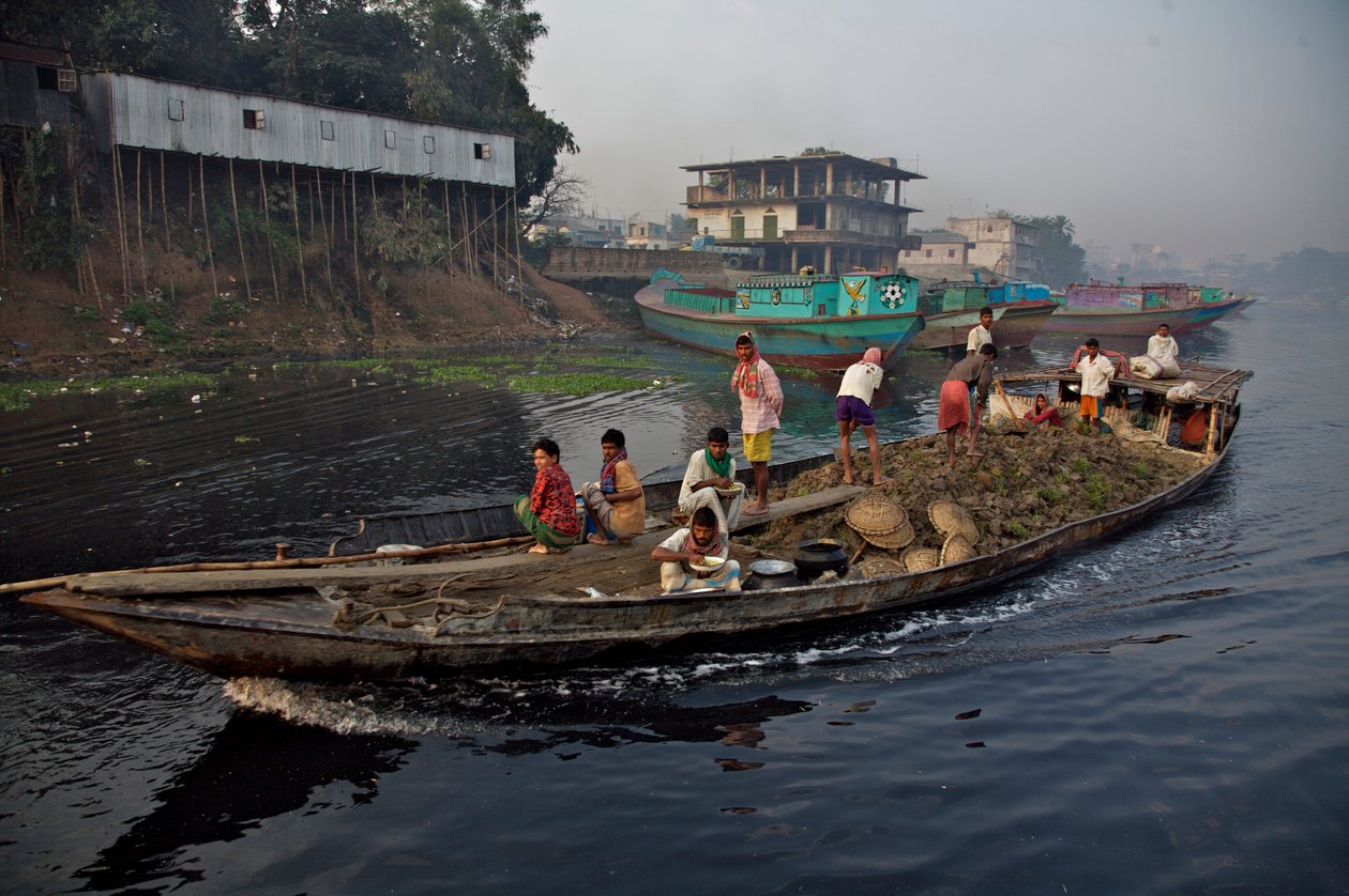 Dakka şehrinin eteklerinde, Tongi köprüsünün yakınında, Shitalakhya Nehri boyunca alçak araziyi doldurmak için kullanılan toprak taşıyan bir tekne. Bangladeş. 19 Şubat 2007. by Unbekannt Unbekannt