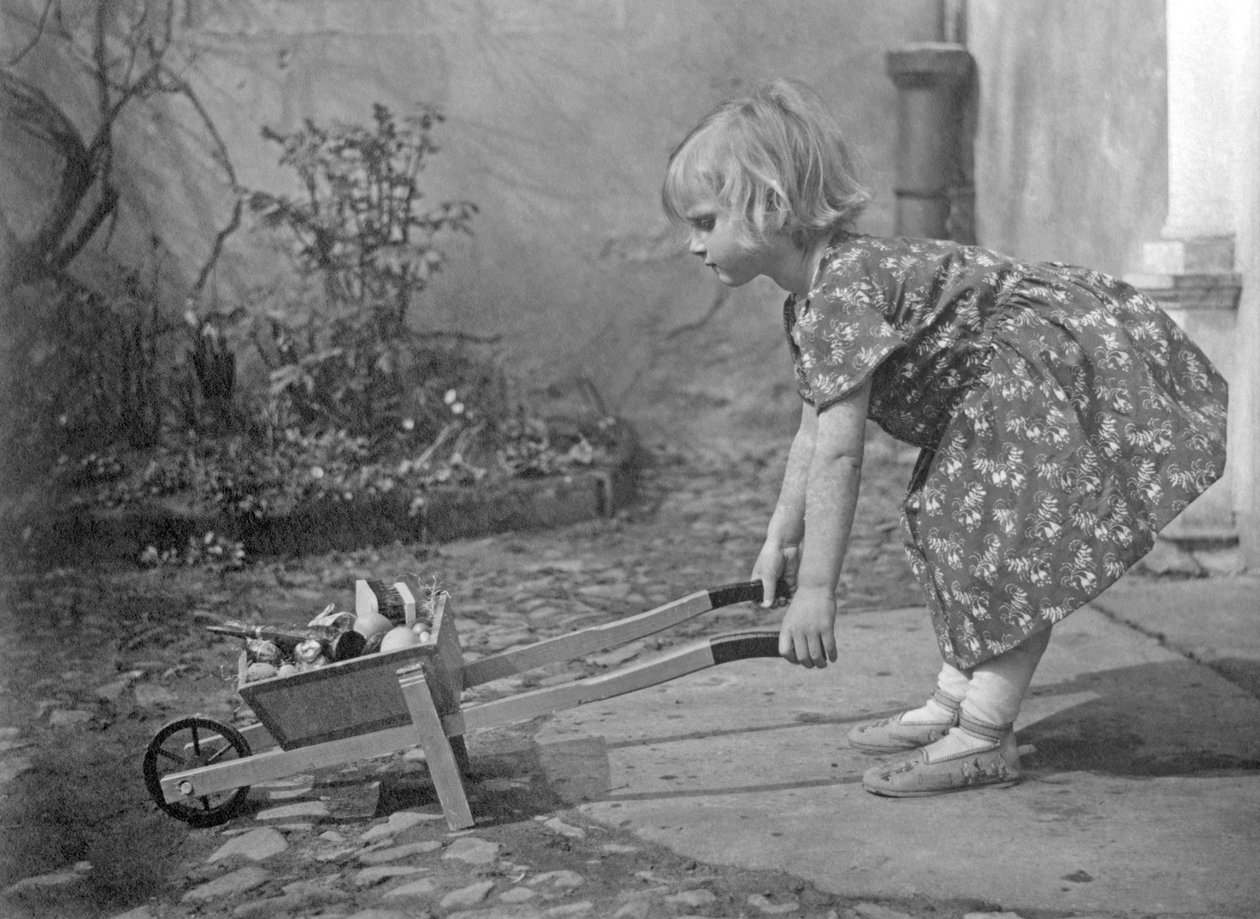El arabasıyla oynayan küçük kız. 1931 civarında fotoğrafçılık by Unbekannt