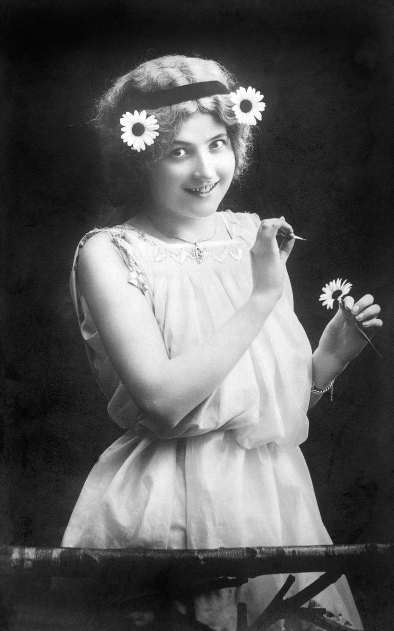 Bir çiçekten yaprak koparan kadın: “” Beni seviyor. Benden hoşlanmıyor. Beni seviyor...” 1912 civarında fotoğraf by Unbekannt