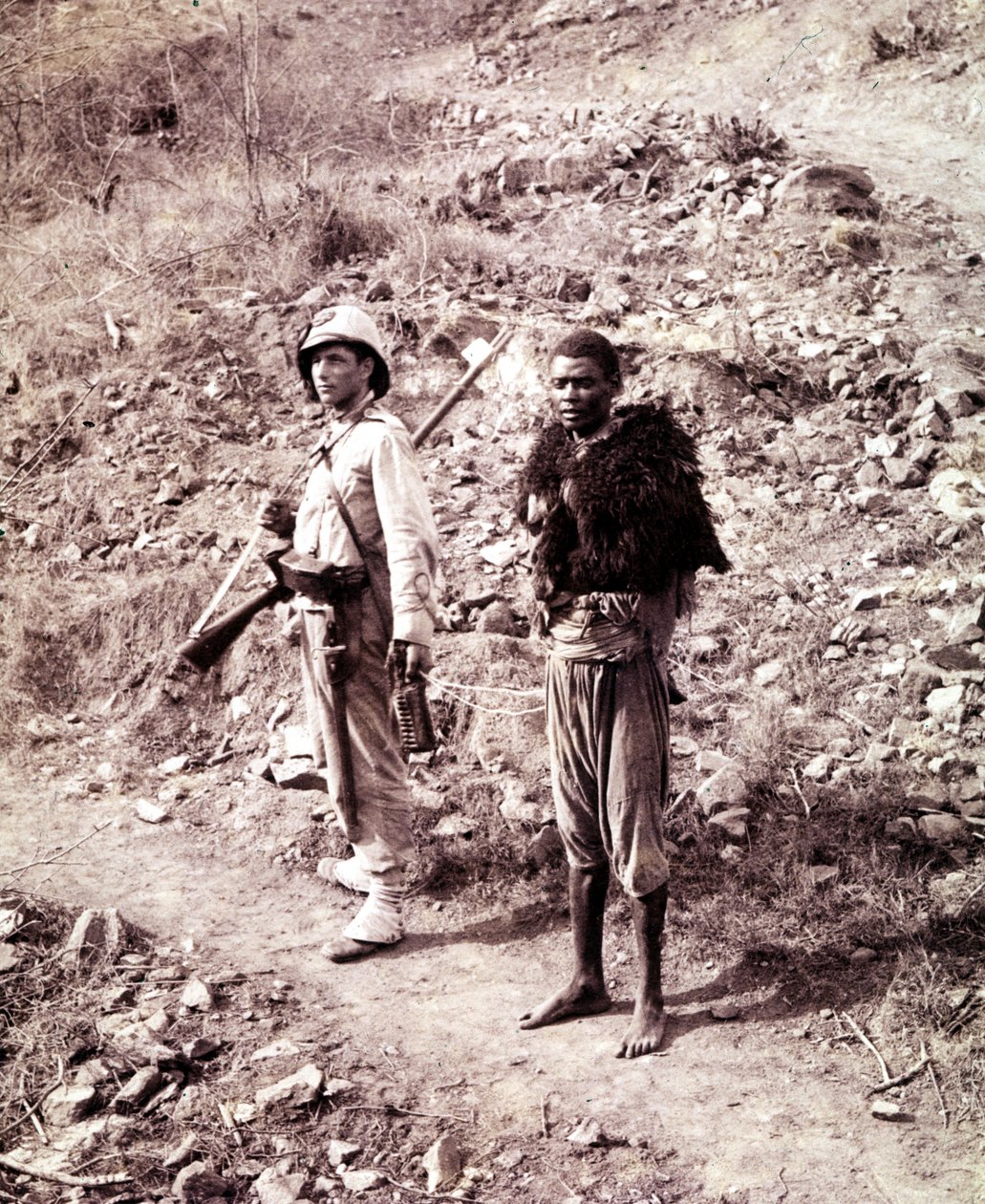 Ghinda yolunda bir İtalyan askeri ve bir Habeş mahkumu. by Unknown photographer
