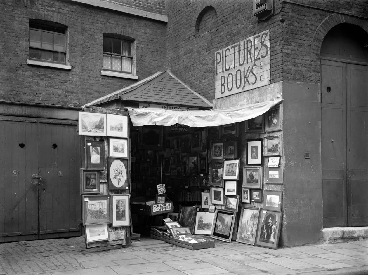 İkinci el kitap ve resim dükkanının önünde sergilenen çerçeveli resimler, Londra, 1933. by WA Clark